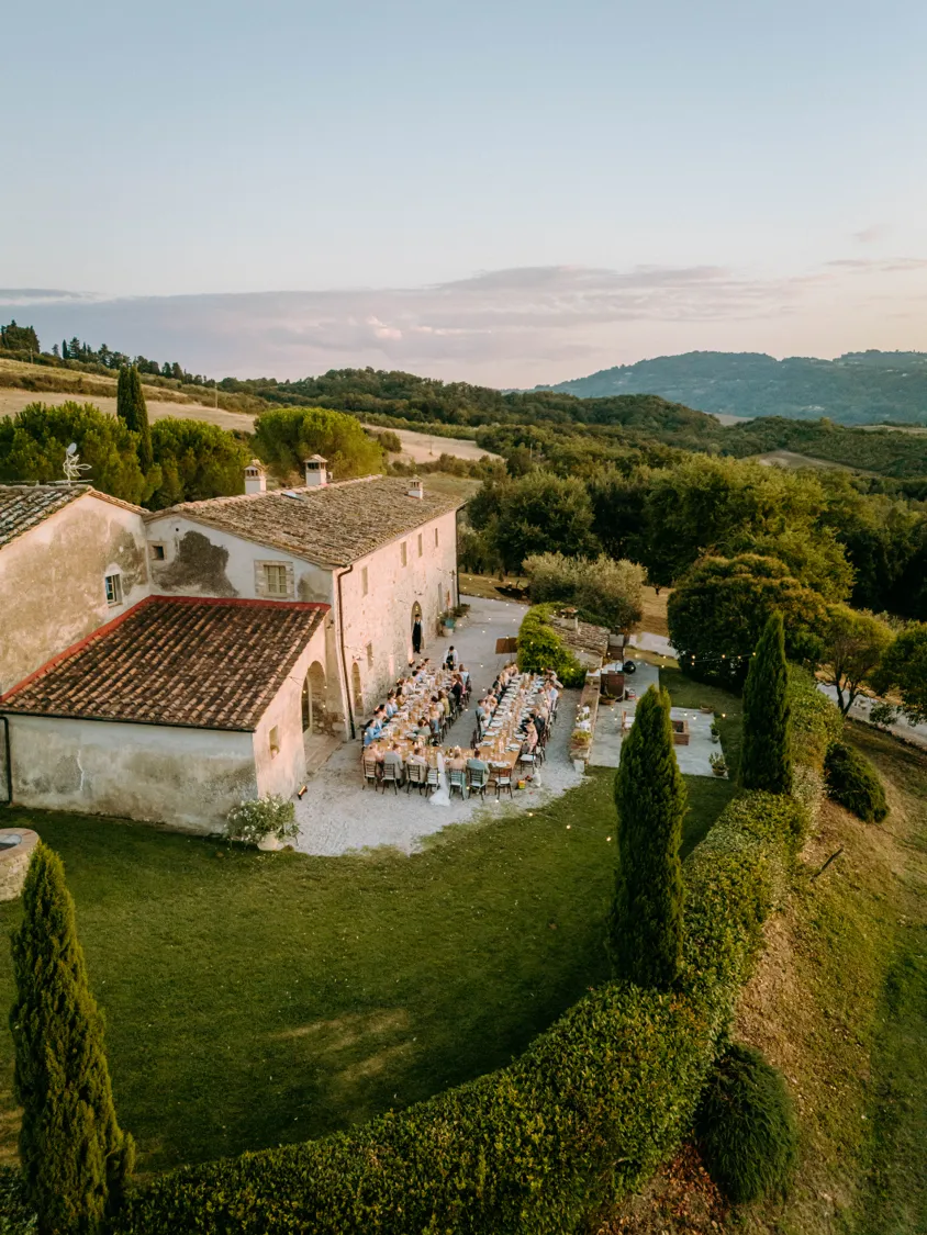 Aerial view of a Tuscan villa wedding dinner at dusk