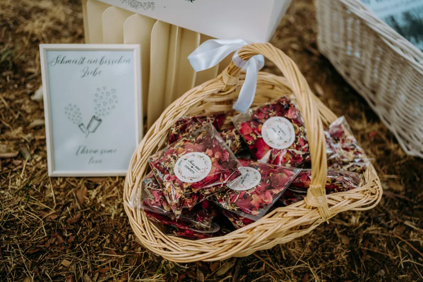 Korb mit Blütenkonfetti-Tütchen und Schild für die Trauung