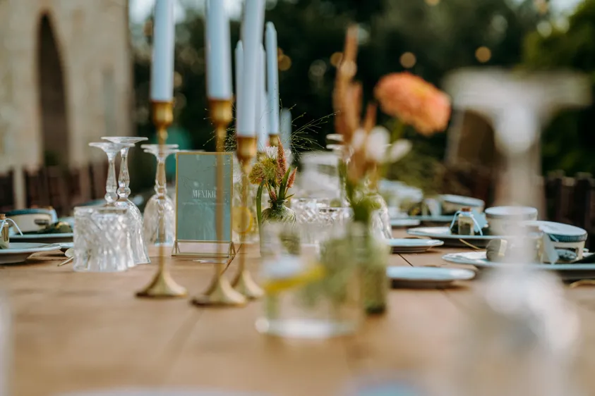 Hochzeitstafel mit Kerzen, Blumen und Tischschild
